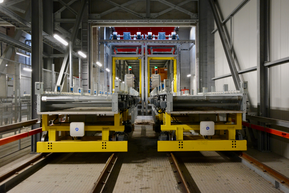 Het kistentransport gebeurt op shuttles doorheen een tunnel op hoogte. Via liften worden de kisten naar beneden gebracht en naar het juiste diepvriesmagazijn gevoerd